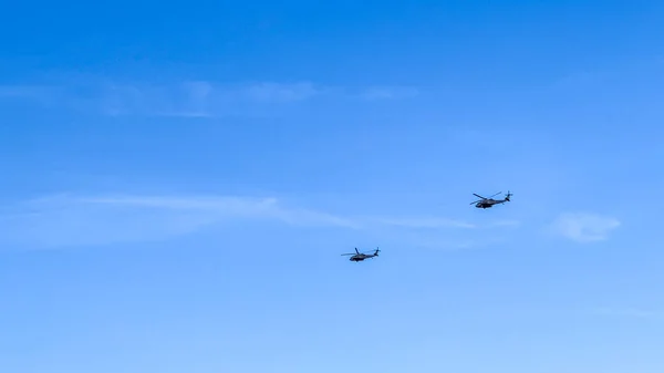 Mavi gökyüzünde uçan helikopter.