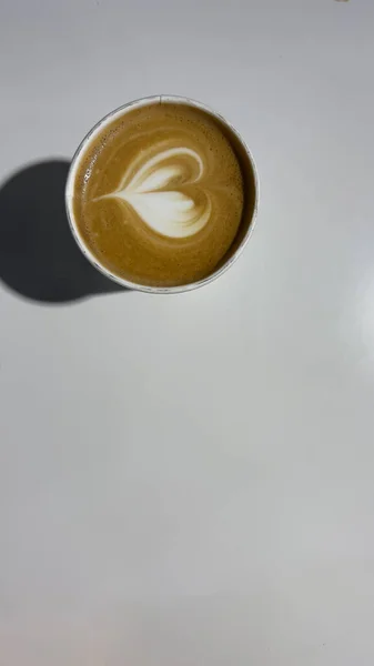 Cup with coffee on white background. Latte art of heart design o