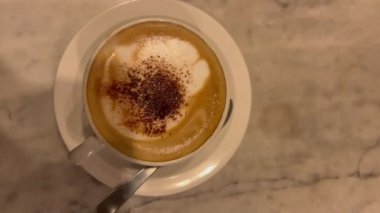 Beyaz bir masada bir fincan latte sanatı.