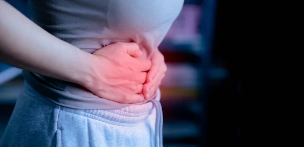 woman, hands on stomach, showing severe abdominal pain, close-up shot, with copy space, physical illness concept, inside the body