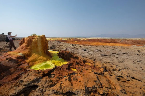 Dallol Gölü 'nde fotoğraf çeken bir turist, Danakil depresyonu, Etiyopya. Danakil Depresyonu 'nda, Erta Ale Dağları' nın kuzeydoğusunda bulunan volkanik bir volkan etrafında eşsiz bir karasal hidrotermal sistem..