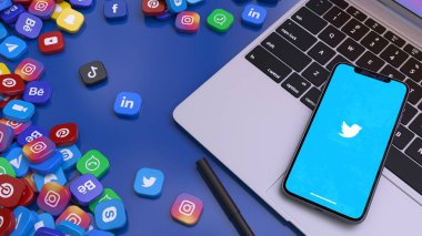 Twitter 'ın simgesini en önemli sosyal ağların rozetleriyle çevrili bir dizüstü bilgisayarda gösteren akıllı bir telefonun 3 boyutlu görüntülenmesi.