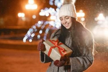 Kış tatili gebeliği. Açık havada genç bir kızın gece portresi. Avrupa sokaklarında poz vermek.