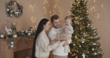 Mutlu aile babası ve bebeği evdeki Noel ağacında. Noel Ailesi. Mutluluk. Baba, anne ve oğul portresi.