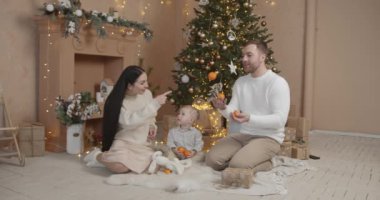 Mutlu aile babası ve bebeği evdeki Noel ağacında. Noel Ailesi. Mutluluk. Baba, anne ve oğul portresi.