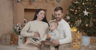 Mutlu aile babası ve bebeği evdeki Noel ağacında. Noel Ailesi. Mutluluk. Baba, anne ve oğul portresi.