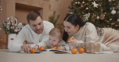 Mutlu aile babası ve bebeği evdeki Noel ağacında. Noel Ailesi. Mutluluk. Baba, anne ve oğul portresi.