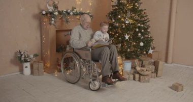Nesiller konsepti. Yaşlı adam küçük torunuyla vakit geçiriyor. Noel süslemeli oda.