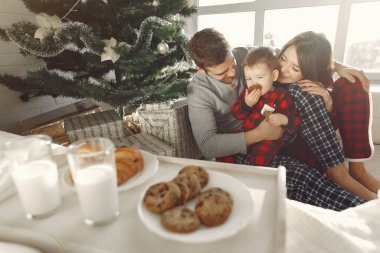 Evdeki insanlar. Pijamalı bir aile. Süt ve kruvasan tepside.