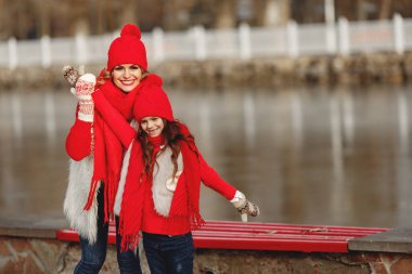 Aile Noel tatilinde örülmüş kış şapkalı anne ve çocuk. Anne ve çocuk için el yapımı yün şapka ve eşarp. Çocuklar için örgü örüyorum. Örgü dış giysi. Parktaki kadın ve küçük kız.