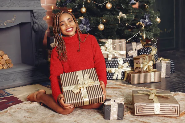 African girl in a Christmas decorations/ Woman in a red sweater. New Year concept.