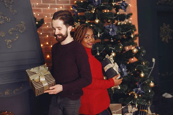 家にいる外国人 クリスマスの飾りのカップル アフリカの女性と白人男性 — ストック写真