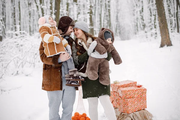 在雪天 父母和孩子们在森林里玩得很开心 快乐的蹒跚学步的女儿和穿着保暖衣服的小儿子 旁边的礼品盒 — 图库照片