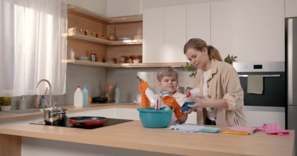 Αγοράκι Και Μητέρα Του Καθαρίζουν Στην Κουζίνα Χρησιμοποιώντας Απορρυπαντικά — Αρχείο Βίντεο