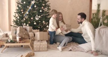 Noel ağacının yanındaki Noel hediyelerini açan ailen. Aileyle Noel tatili.