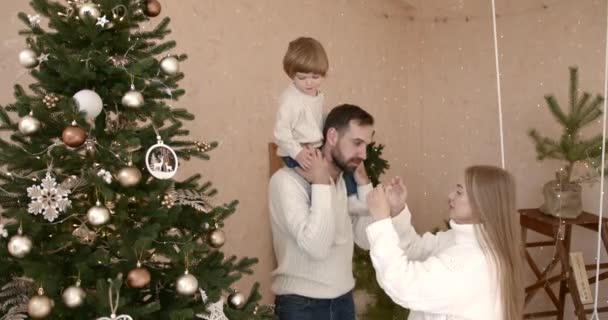 Jongeman Met Zijn Zoontje Vrouw Die Thuis Kerstboom Versiert Curios — Stockvideo