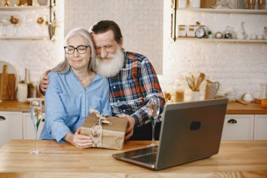 Yaş ve insan kavramı. Evde kıdemli bir çift var. İnsanlar Noel 'i online kutluyor.