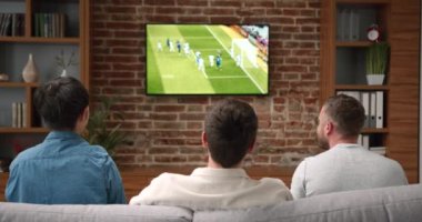 Genç arkadaşların televizyonda tezahürat yapıp maç izlediği mutlu zamanlar. Spor ve eğlence konsepti.