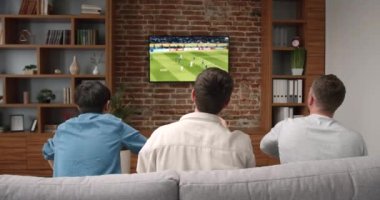 Genç arkadaşların televizyonda tezahürat yapıp maç izlediği mutlu zamanlar. Spor ve eğlence konsepti.