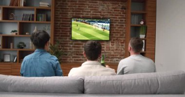 Genç arkadaşların televizyonda tezahürat yapıp maç izlediği mutlu zamanlar. Spor ve eğlence konsepti.