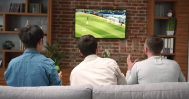 Genç arkadaşların televizyonda tezahürat yapıp maç izlediği mutlu zamanlar. Spor ve eğlence konsepti.