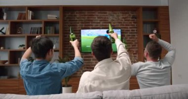 Genç arkadaşların televizyonda tezahürat yapıp maç izlediği mutlu zamanlar. Spor ve eğlence konsepti.