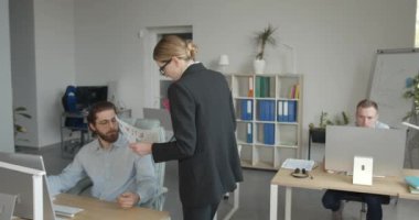 Bayan patron genç meslektaşlarına yardım ediyor. Kadın yönetici modern ofisteki çalışanları motive eder. 4K.