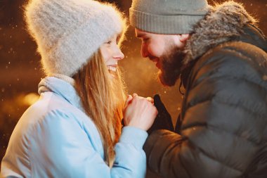 Kış tatili gebeliği. Genç bir çiftin açık hava gece portresi. Avrupa sokaklarında poz vermek.