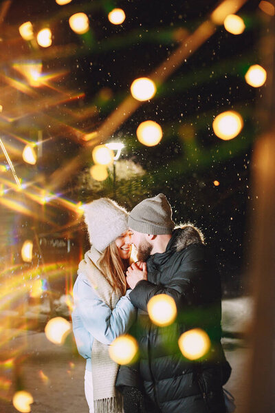 Концепция зимних каникул. Портрет молодой пары на открытом воздухе. Позирование на улице европейского города.