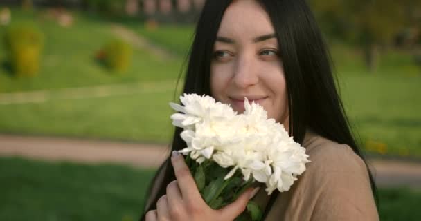 妊娠中の女性が公園で花を嗅ぐ 妊娠中や母親の考え方 — ストック動画