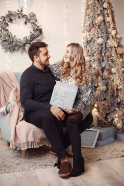 Noel süsü takmış insanlar. Gri kazaklı adam. Aile evde..