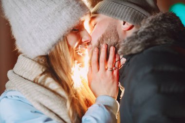 Kış tatili gebeliği. Genç bir çiftin açık hava gece portresi. Avrupa sokaklarında poz vermek.