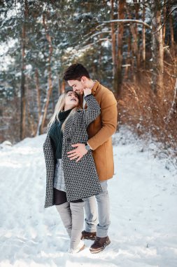 karlı bir günde parkta yürüyen mutlu genç çift