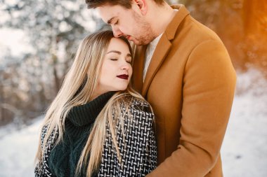 karlı bir günde parkta yürüyen mutlu genç çift