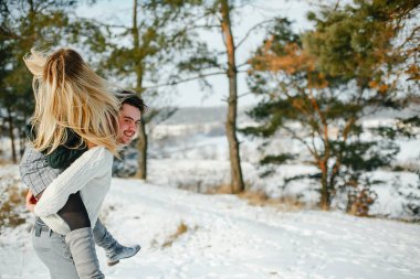 mutlu çift öpüşme ve karlı bir kış gününde parkta sarılma