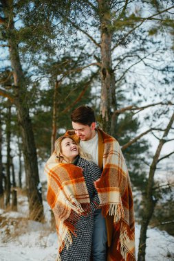 mutlu çift karlı bir günde parkta duran bir battaniye sarılmış