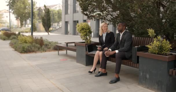 黑人男性和白人女性在户外有一个休息或商务会议 他们正在讨论一些想法和项目 商界人士衣着得体 — 图库视频影像