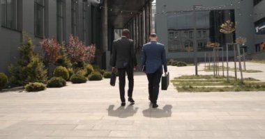 Ofis binasının önündeki kaldırımda yürüyen iş adamları. Başarılı ve hırslı iş arkadaşları ve kadın patronlardan oluşan bir takım. İşbirliği. Kariyer.