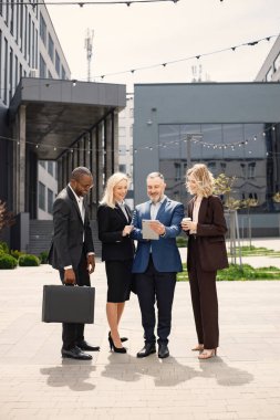 Modern ofis binasının önünde duran kendinden emin iş adamları. Erkekler ve kadınlar konuşuyorlar ve belgelere bakıyorlar. Bankacılık ve finans piyasası kavramı.