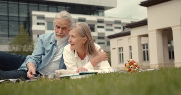 Härligt Moget Par Picknick Ängen Nära Modern Byggnad Aktiv Pensionering — Stockvideo