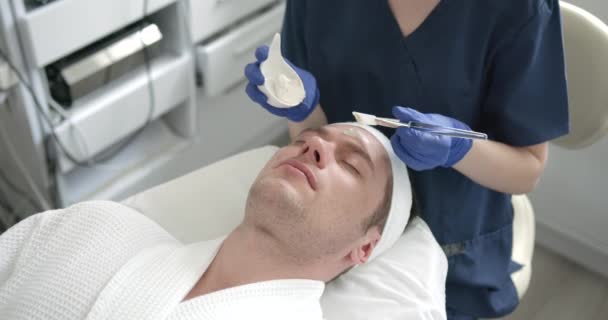 Cosmetologist Applying Clay Mask Mans Face Spa Salon Beautician Doing — Vídeo de stock