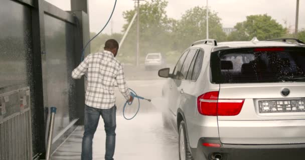 Ένας Νεαρός Πλένει Αμάξι Του Ένα Πλυντήριο Αυτοκινήτων Ένας Μαύρος — Αρχείο Βίντεο