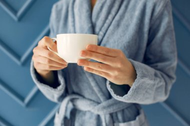 Stüdyodaki kız. Mavi bornozlu kadın. Kahve içen kadın.