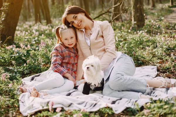 Family in a spring park. Girl with cute dog. Mother with daughter.