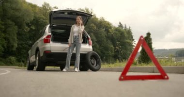 Broken down car on a road with red warning triangle. Flat tire problem.