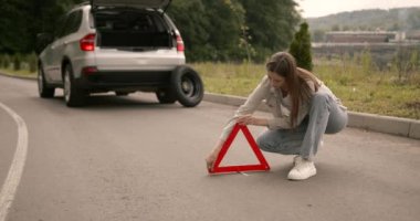 Broken down car on a road with red warning triangle. Flat tire problem.