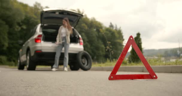 赤い警告の三角形の道路上で車を破壊した 平らなタイヤの問題 — ストック動画