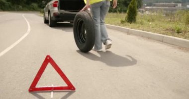 Broken down car on a road with red warning triangle. Flat tire problem.