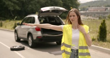 Disappointed girl trying to stop cars on the road. Woman asking for asisstance with broken car.