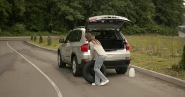 Girl changing a punctured tire at the car. Repair of cars on the road. Accident concept.